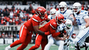 Louisville Cardinals defensive lineman AJ Green (17) grabs Kentucky Wildcats quarterback Cutter Boley (8) as Louisville Cardinals defensive lineman Clev Lubin (50) helps in the first half Saturday, November 29, 2025 in Louisville, Kentucky at L&N Federal Credit Union Stadium.