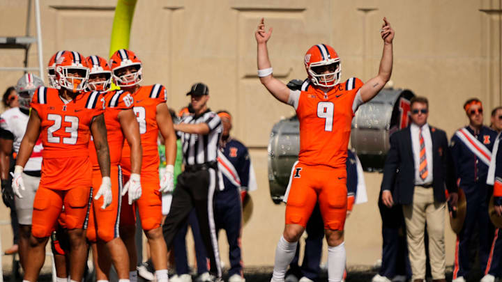 Believing he crossed the goal line, Illinois Fighting Illini quarterback Luke Altmyer (9) reacts to watching a replay of his run on the video board during the second half of the NCAA football game against the Ohio State Buckeyes at Gies Memorial Stadium in Champaign on Oct. 11, 2025. Replay did not confirm Altmyer's beliefs.