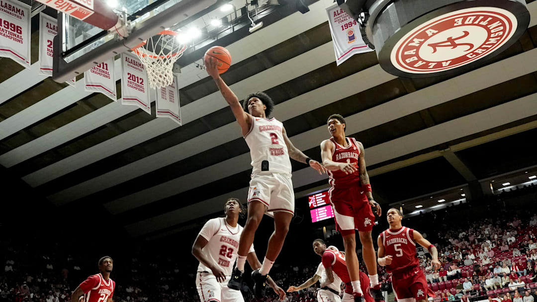 Feb 18, 2026; Tuscaloosa, AL, USA; Alabama guard Aden Holloway (2) goes for a layup past Arkansas guard Meleek Thomas (1) at Coleman Coliseum. Mandatory Credit: Gary Cosby Jr.-Tuscaloosa News