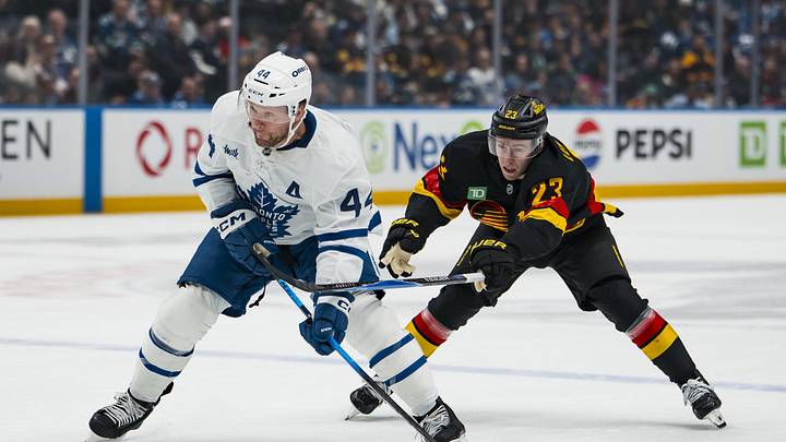 Jan 31, 2026; Vancouver, British Columbia, CAN; Vancouver Canucks forward Jonathan Lekkerimaki (23) stick checks Toronto Maple Leafs defenseman Morgan Rielly (44) in the first period at Rogers Arena. Mandatory Credit: Bob Frid-Imagn Images