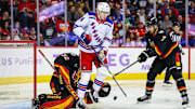Nov 21, 2024; Calgary, Alberta, CAN; New York Rangers right wing Kaapo Kakko (24) screens in front of Calgary Flames goaltender Dustin Wolf (32) during the third period at Scotiabank Saddledome. Mandatory Credit: Sergei Belski-Imagn Images