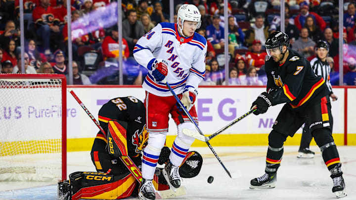 Nov 21, 2024; Calgary, Alberta, CAN; New York Rangers right wing Kaapo Kakko (24) screens in front of Calgary Flames goaltender Dustin Wolf (32) during the third period at Scotiabank Saddledome. Mandatory Credit: Sergei Belski-Imagn Images