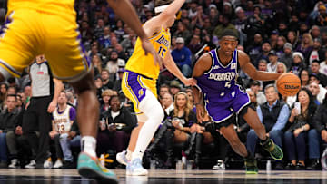 Dec 19, 2024; Sacramento, California, USA; Sacramento Kings guard De'Aaron Fox (5) dribbles the ball next to Los Angeles Lakers guard Austin Reaves (15) in the fourth quarter at the Golden 1 Center. Mandatory Credit: Cary Edmondson-Imagn Images