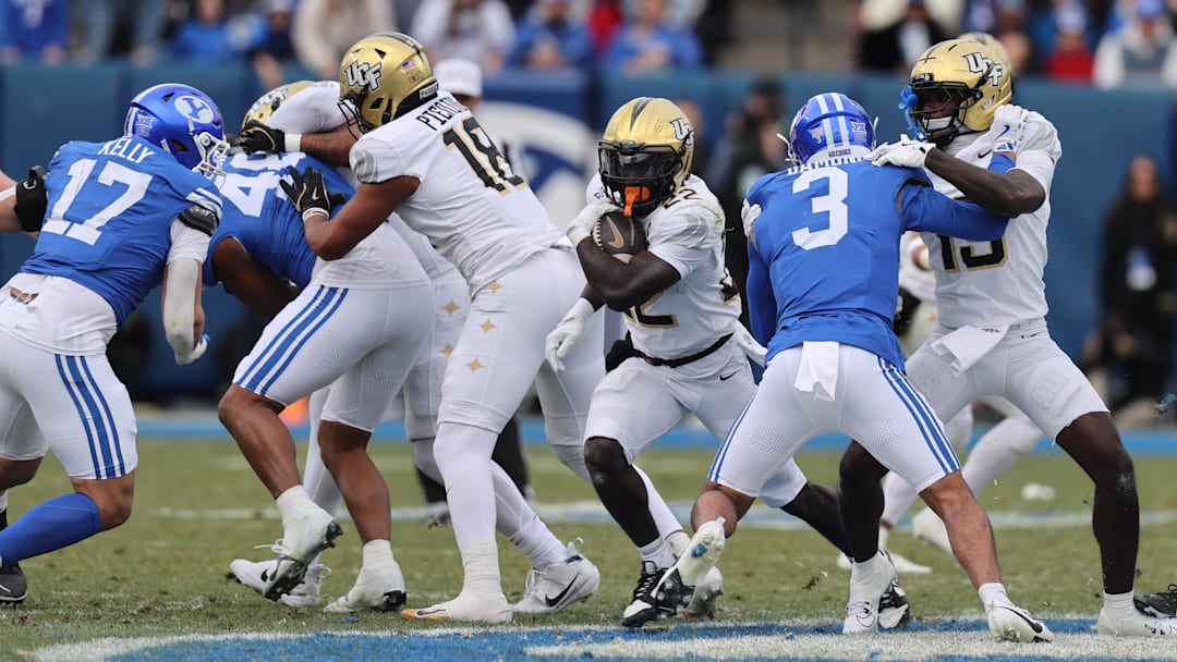 Nov 29, 2025; Provo, Utah, USA; UCF Knights running back Myles Montgomery (22) runs the ball against the BYU Cougars during the second half at LaVell Edwards Stadium. Mandatory Credit: Rob Gray-Imagn Images