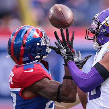 Sep 8, 2024; East Rutherford, New Jersey, USA; Minnesota Vikings wide receiver Justin Jefferson (18) attempts to catch a pass as New York Giants safety Jason Pinnock (27) defends during the second half at MetLife Stadium. Mandatory Credit: Vincent Carchietta-Imagn Images