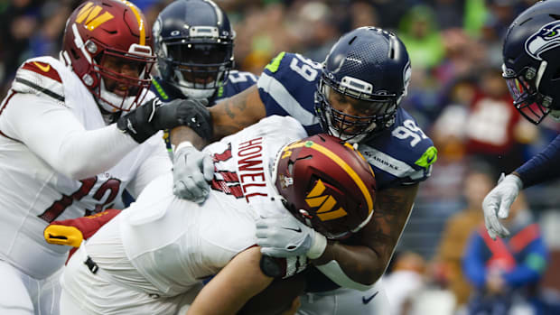 Seattle Seahawks defensive end Leonard Williams (99) sacks Washington Commanders quarterback Sam Howell (14).