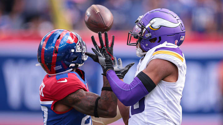 Sep 8, 2024; East Rutherford, New Jersey, USA; Minnesota Vikings wide receiver Justin Jefferson (18) attempts to catch a pass as New York Giants safety Jason Pinnock (27) defends during the second half at MetLife Stadium. Mandatory Credit: Vincent Carchietta-Imagn Images