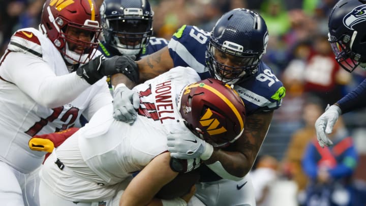 Nov 12, 2023; Seattle, Washington, USA; Seattle Seahawks defensive end Leonard Williams (99) sacks Washington Commanders quarterback Sam Howell (14) during the second quarter at Lumen Field. Mandatory Credit: Joe Nicholson-USA TODAY Sports