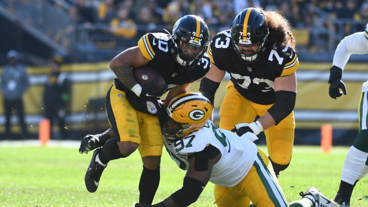 Nov 12, 2023; Pittsburgh, Pennsylvania, USA;  Pittsburgh Steelers running back Jaylen Warren (30) and Green Bay Packers defensive lineman Kenny Clark (97) as offensive lineman Isaac Seumalo (73) follows the play during the first quarter at Acrisure Stadium. Mandatory Credit: Philip G. Pavely-USA TODAY Sports