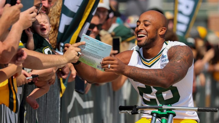 Packers RB AJ Dillon signs a copy of his book at training camp.