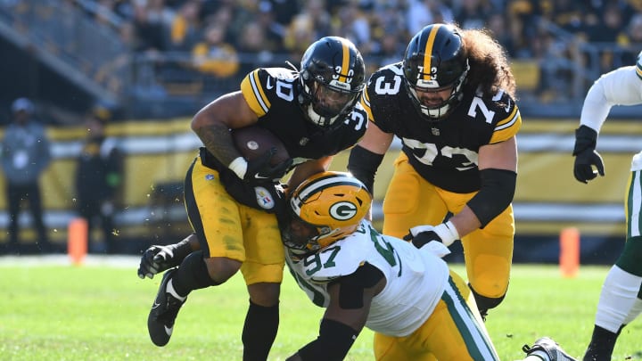 Nov 12, 2023; Pittsburgh, Pennsylvania, USA;  Pittsburgh Steelers running back Jaylen Warren (30) and Green Bay Packers defensive lineman Kenny Clark (97) as offensive lineman Isaac Seumalo (73) follows the play during the first quarter at Acrisure Stadium. Mandatory Credit: Philip G. Pavely-USA TODAY Sports