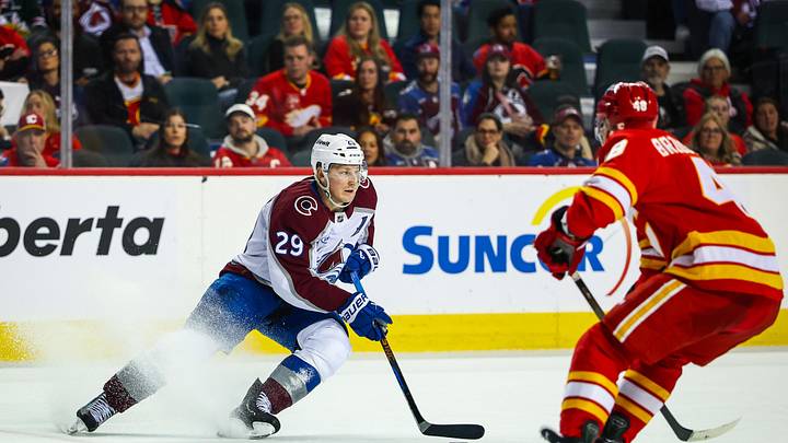 Apr 14, 2026; Calgary, Alberta, CAN; Colorado Avalanche center Nathan MacKinnon (29) controls the puck against Calgary Flames defenseman Hunter Brzustewicz (48) during the third period at Scotiabank Saddledome. Mandatory Credit: Sergei Belski-Imagn Images