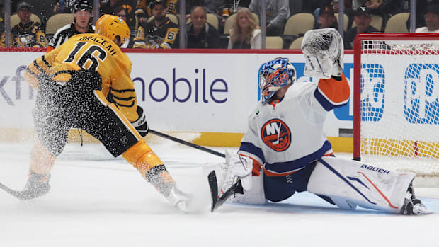 Hockey player shoots puck over goali