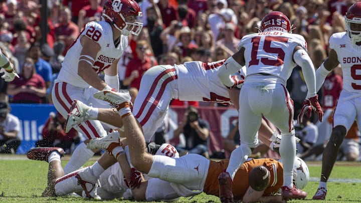 Oct 7, 2023; Dallas, Texas, USA; Texas Longhorns quarterback Quinn Ewers (3) fumbles the ball after he is sacked by Oklahoma Sooners linebacker Danny Stutsman (28) and defensive lineman Ethan Downs (40) and defensive back Kendel Dolby (15) during the second half at the Cotton Bowl. 