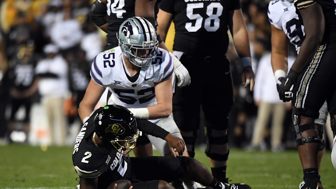 Oct 12, 2024; Boulder, Colorado, USA; Colorado Buffaloes quarterback Shedeur Sanders (2) is sacked by Kansas State Wildcats defensive end Ryan Davis (52) during the second half at Folsom Field. Mandatory Credit: Christopher Hanewinckel-Imagn Images
