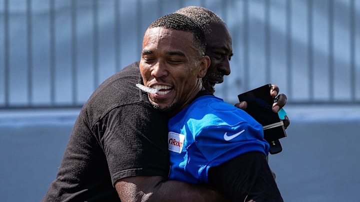 Detroit Lions wide receiver Amon-Ra St. Brown (14) hugs Lions great Lomas Brown after practice during training camp at Meijer Performance Center in Allen Park on Monday, July 21, 2025.