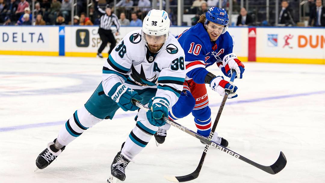 Oct 20, 2022; New York, New York, USA; San Jose Sharks defenseman Mario Ferraro (38) and New York Rangers left wing Artemi Panarin (10) fight for the puck during the third period at Madison Square Garden. Mandatory Credit: Danny Wild-Imagn Images