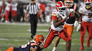 Nov 15, 2025; Champaign, Illinois, USA; Maryland Terrapins running back DeJuan Williams (0) drags defender Illinois Fighting Illini defensive back Tanner Heckel (16) during the second half at Memorial Stadium. Mandatory Credit: Ron Johnson-Imagn Images