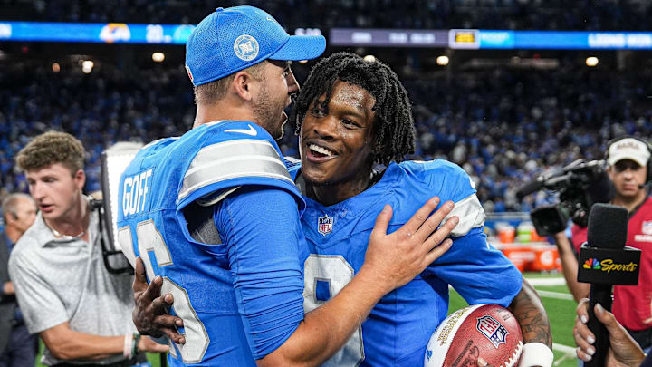 Detroit Lions quarterback Jared Goff (16) hugs wide receiver Jameson Williams (9).