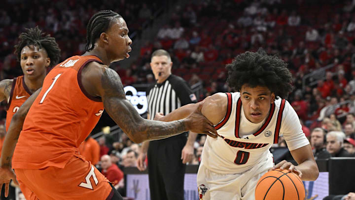 Jan 24, 2026; Louisville, Kentucky, USA;  Louisville Cardinals guard Mikel Brown Jr. (0) dribbles against Virginia Tech Hokies forward Tobi Lawal (1) during the second half at KFC Yum! Center. Mandatory Credit: Jamie Rhodes-Imagn Images