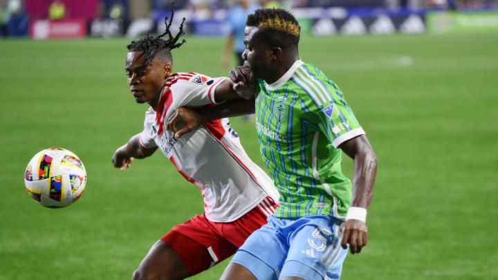 Jul 6, 2024; Seattle, Washington, USA; New England Revolution defender DeJuan Jones (24) and Seattle Sounders FC defender Nouhou (5) battle for the ball in the second half at Lumen Field. Mandatory Credit: Steven Bisig-USA TODAY Sports