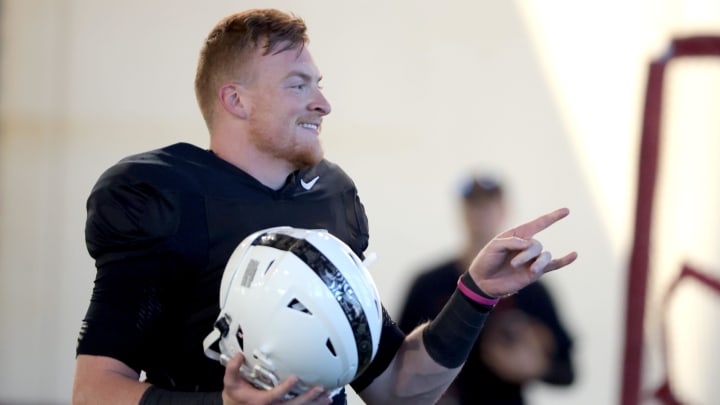 Oklahoma State quarterback Alan Bowman talks with teammates during a spring football practice