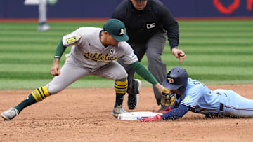 Jun 1, 2025; Toronto, Ontario, CAN; Toronto Blue Jays first baseman Ernie Clement (22) beats the tag from Athletics second baseman Luis Urias (17) to slide safely to second base on a double during the eighth inning at Rogers Centre. Mandatory Credit: John E. Sokolowski-Imagn Images