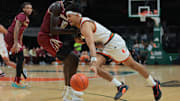 Jan 8, 2025; Coral Gables, Florida, USA; Miami Hurricanes guard Jalen Blackmon (5) drives to the basket past Florida State Seminoles forward Taylor Bol Bowen (10) during the second half at Watsco Center. Mandatory Credit: Sam Navarro-Imagn Images