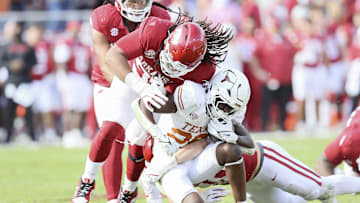 Nov 16, 2024; Fayetteville, Arkansas, USA; Texas Longhorns running back Quintrevion Wisner (26) is tackled in the fourth quarter by Arkansas Razorbacks defensive lineman Keivie Rose (93) at Donald W. Reynolds Razorback Stadium. Texas won 20-10. Mandatory Credit: Nelson Chenault-Imagn Images