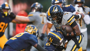 American Heritage Patriots running back Byron Louis (7) is tackled by Naples Golden Eagles linebacker Khari Bendolph (21) during the first quarter of a game at Staver Field in Naples on Friday, Sept. 13, 2024.