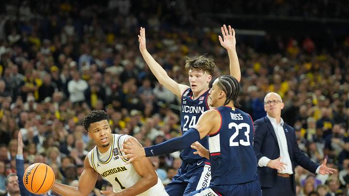 Apr 6, 2026; Indianapolis, IN, USA; Michigan Wolverines guard Trey McKenney (1) is defended by Connecticut Huskies guard Braylon Mullins (24) and Connecticut Huskies forward Jayden Ross (23) in the second half during the national championship of the Final Four of the men's 2026 NCAA Tournament at Lucas Oil Stadium. Mandatory Credit: Robert Deutsch-Imagn Images