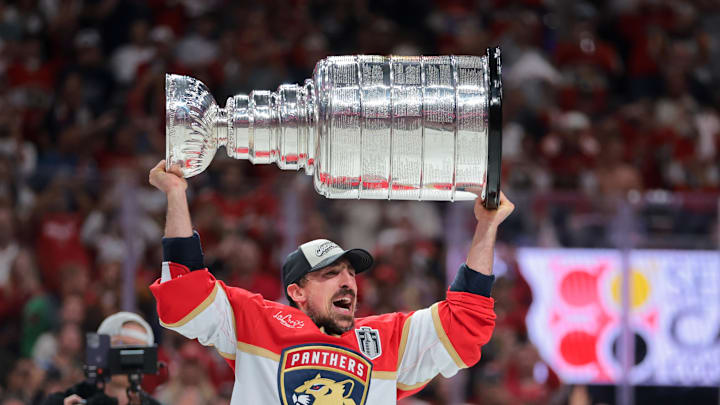 Jun 17, 2025; Sunrise, Florida, USA; Florida Panthers center Brad Marchand (63) hoists the Stanley Cup after winning game six of the 2025 Stanley Cup Final against the Edmonton Oilers at Amerant Bank Arena. Jun 17, 2025; Sunrise, Florida, USA; Florida Panthers center Brad Marchand (63) hoists the Stanley Cup after winning game six of the 2025 Stanley Cup Final against the Edmonton Oilers at Amerant Bank Arena.