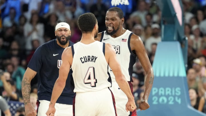 Aug 8, 2024; Paris, France; United States centre Anthony Davis (left), guard Kevin Durant (right) and shooting guard Stephen Curry (4) celebrate during the second half against Serbia in a men's basketball semifinal game during the Paris 2024 Olympic Summer Games at Accor Arena. Mandatory Credit: Kyle Terada-USA TODAY Sports