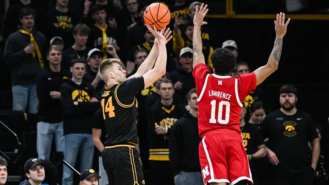 Feb 17, 2026; Iowa City, Iowa, USA; Iowa Hawkeyes guard Bennett Stirtz (14) shoots the ball over Nebraska Cornhuskers guard Jamarques Lawrence (10) during the first half at Carver-Hawkeye Arena. Mandatory Credit: Jeffrey Becker-Imagn Images