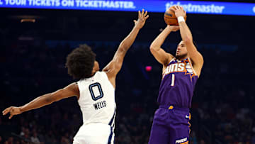Oct 29, 2025; Phoenix, Arizona, USA; Phoenix Suns guard Devin Booker (1) shoots the ball against Memphis Grizzlies forward Jaylen Wells (0) during the first half at the Mortgage Matchup Center. Mandatory Credit: Mark J. Rebilas-Imagn Images
