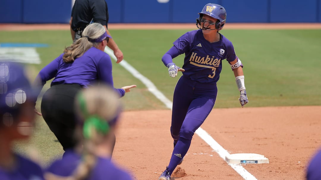 June 2: Washington's Rylee Holtorf rounds third base past head coach Heather Tarr after hitting a two-run homer against Utah in the second inning. The Huskies won Game 4 of the WCWS 4-1.