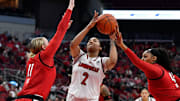 Louisville forward Nyla Harris (2) attempts a shot through the defense of NC State forward Maddie Cox (11), left, and center Mallory Collier (42) during the first half of an NCAA college basketball game, Sunday, Dec. 15 2024 in Louisville Ky.