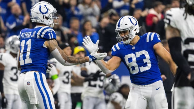 Colts tight end Kylen Granson (blue jersey with white pants/helmet) celebrates a big play with a teammate. 