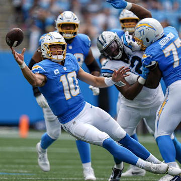 Sep 15, 2024; Charlotte, North Carolina, USA; Los Angeles Chargers quarterback Justin Herbert (10) throws a pass under pressure during the first quarter against the Carolina Panthers at Bank of America Stadium.