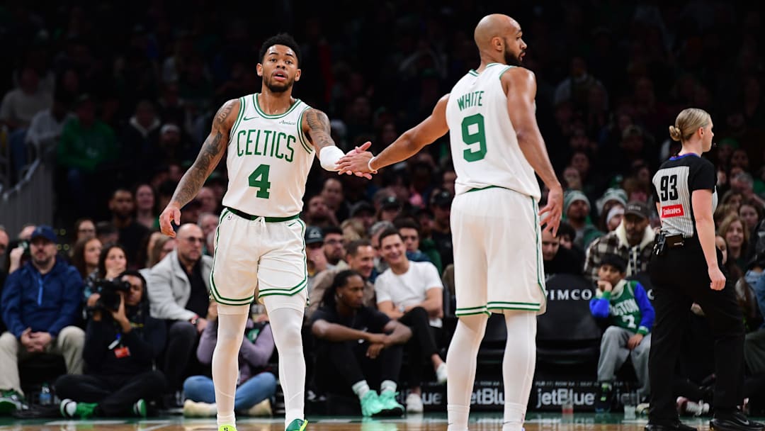 Nov 23, 2025; Boston, Massachusetts, USA; Boston Celtics guard Anfernee Simons (4) is congratulated by guard Derrick White (9) after a basket during the first half at TD Garden. Mandatory Credit: Bob DeChiara-Imagn Images
