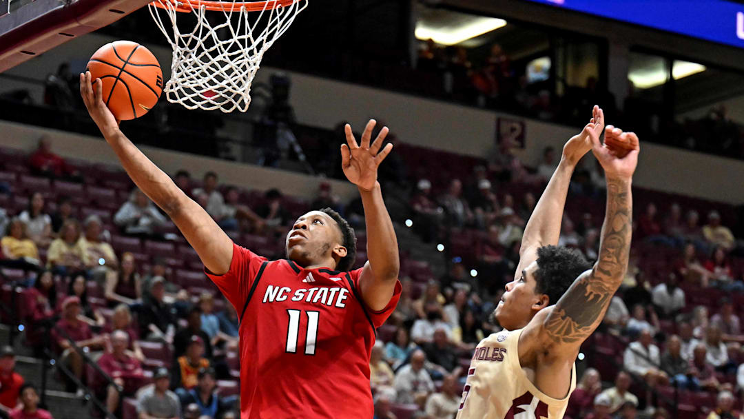 Jan 10, 2026; Tallahassee, Florida, USA; North Carolina State Wolfpack guard Quadir Copeland (11) shoots the ball past Florida State Seminoles guard Kobe MaGee (5) during the second half at Donald L. Tucker Center. Mandatory Credit: Melina Myers-Imagn Images