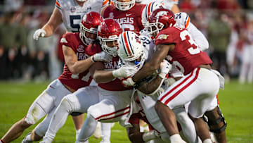 Nov 11, 2023; Fayetteville, Arkansas, USA;  Arkansas Razorbacks defensive back Hudson Clark (17) and defensive lineman Keivie Rose (93) and linebacker Jordan Crook (36) tackle Auburn Tigers running back Damari Alston (22) during the third quarter at Donald W. Reynolds Razorback Stadium. Auburn won 48-10. Mandatory Credit: Brett Rojo-Imagn Images