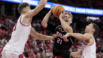 Southern Illinois-Edwardsville forward Myles Thompson (21) drives between Wisconsin forward Will Garlock (23) and guard Jack Janicki (5) during the first half of their game Monday, November 17, 2025 at the Kohl Center in Madison, Wisconsin.
