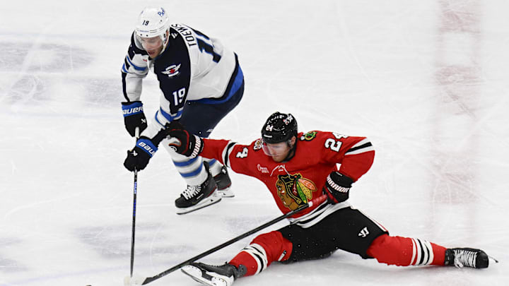 Jan 19, 2026; Chicago, Illinois, USA;  Winnipeg Jets center Jonathan Toews (19) vies for the puck against Chicago Blackhawks center Sam Lafferty (24) during the third period at United Center. Mandatory Credit: Matt Marton-Imagn Images