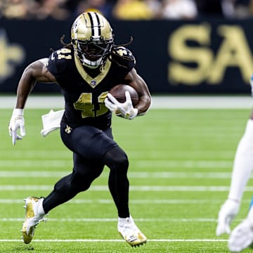 Sep 8, 2024; New Orleans, Louisiana, USA;  New Orleans Saints running back Alvin Kamara (41) runs against Carolina Panthers cornerback Jaycee Horn (8) during the first half at Caesars Superdome. Mandatory Credit: Stephen Lew-Imagn Images