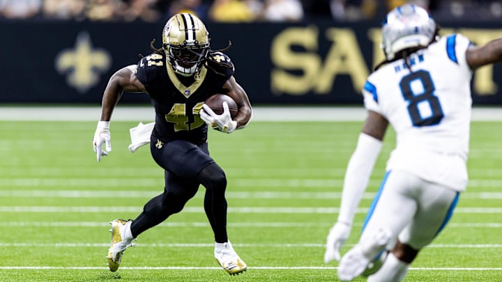 Sep 8, 2024; New Orleans, Louisiana, USA;  New Orleans Saints running back Alvin Kamara (41) runs against Carolina Panthers cornerback Jaycee Horn (8) during the first half at Caesars Superdome. Mandatory Credit: Stephen Lew-Imagn Images