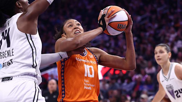 Connecticut Sun center Olivia Nelson-Odada drives to the basket with a basketball wearing an orange jersey