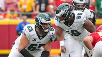 Sep 14, 2025; Kansas City, Missouri, USA; Philadelphia Eagles offensive tackle Lane Johnson (65) talks with guard Tyler Steen (56) on the line of scrimmage against the Kansas City Chiefs during the game at GEHA Field at Arrowhead Stadium. Mandatory Credit: Denny Medley-Imagn Images