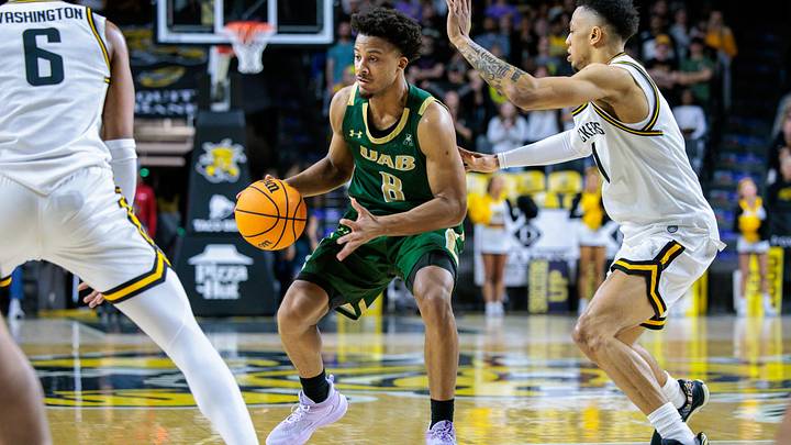 Feb 27, 2025; Wichita, Kansas, USA; UAB Blazers guard Efrem Johnson (8) sets the play around Wichita State Shockers guard Xavier Bell (1) during the first half at Charles Koch Arena. Mandatory Credit: William Purnell-Imagn Images