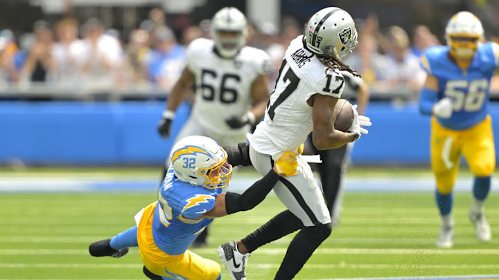 Sep 8, 2024; Inglewood, California, USA; Las Vegas Raiders wide receiver Davante Adams (17) is stopped by Los Angeles Chargers safety Alohi Gilman (32) after a compete pass in the first half at SoFi Stadium. Mandatory Credit: Jayne Kamin-Oncea-Imagn Images